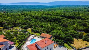 A villa with a swimming pool, surrounded by dense forest and a view of distant mountains. - Villa Loni with Pool & Seaview (Bajčići (Krk))