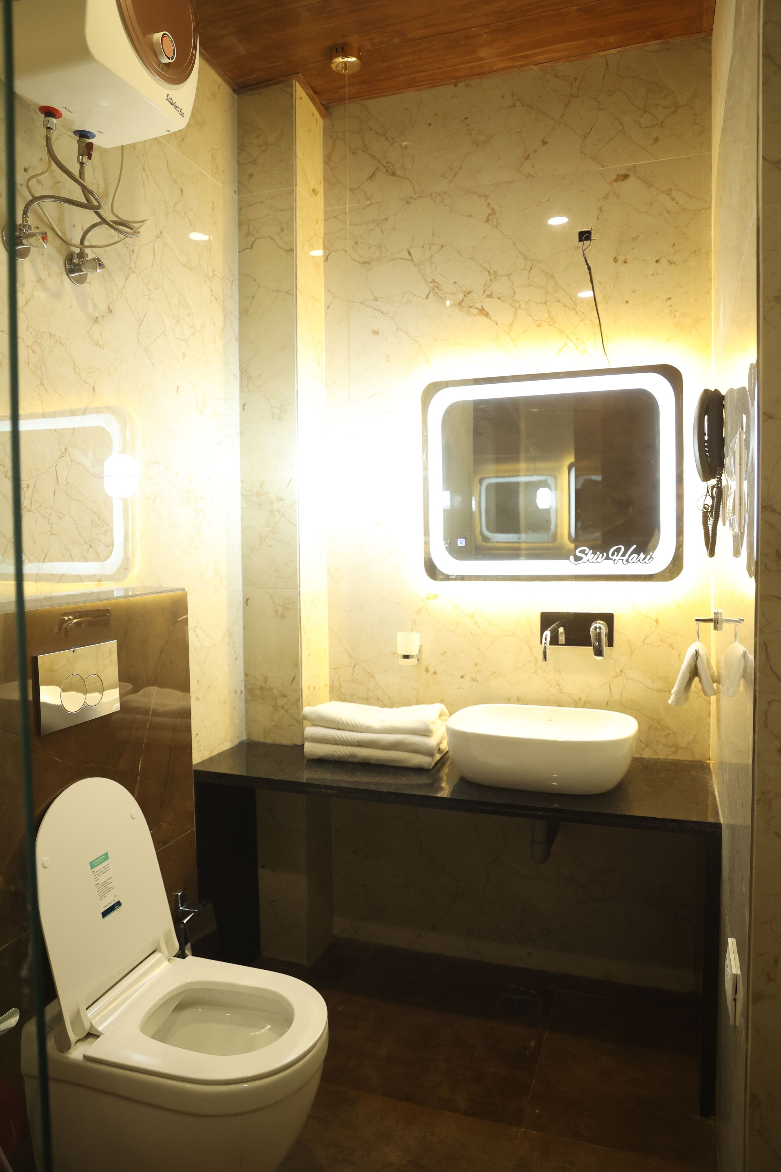 A modern bathroom with a toilet, sink, and mirror.