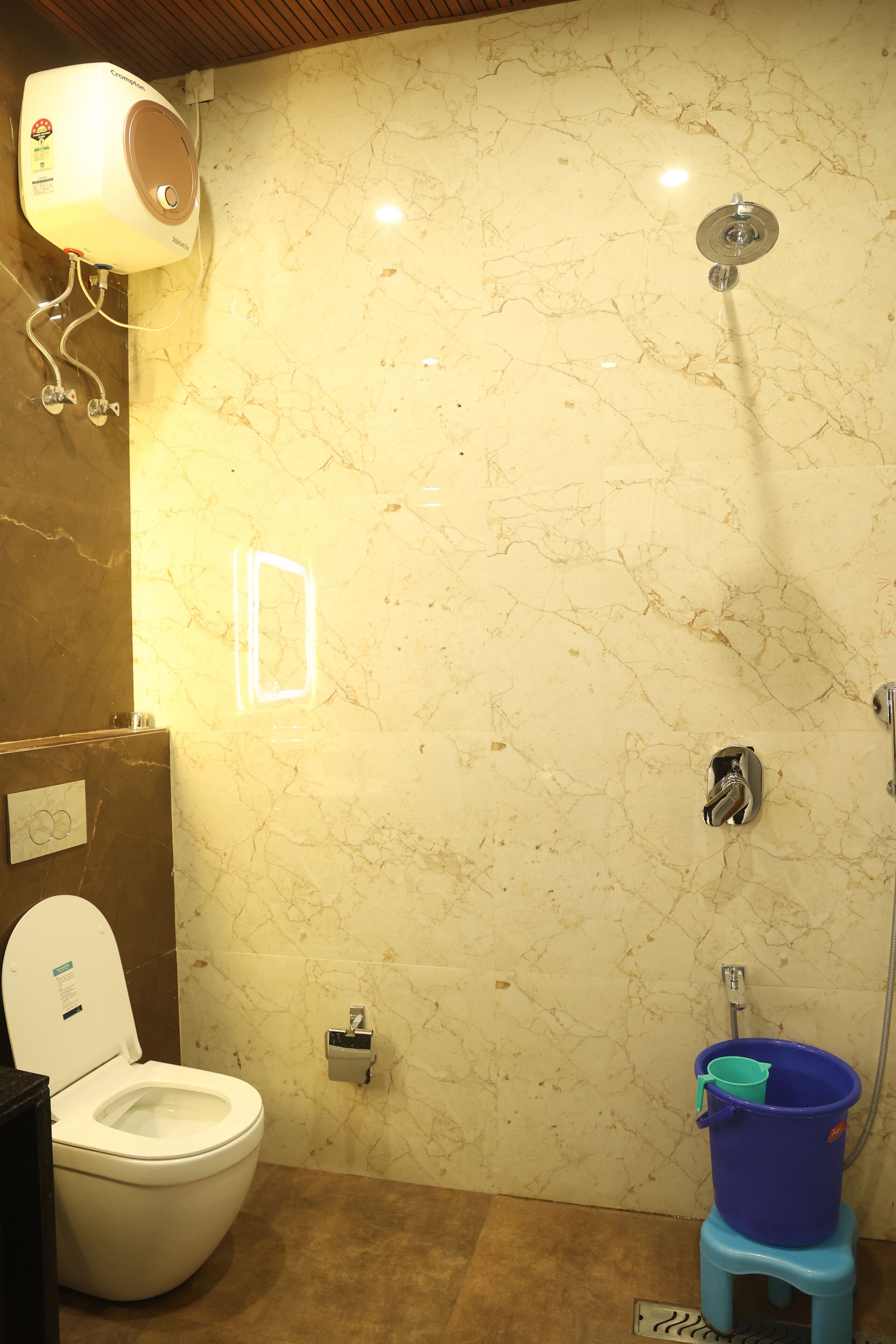 A bathroom with a toilet, a shower, and a hand dryer.