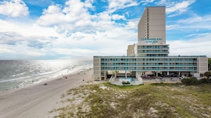 A hotel with a pool, beach access, and a view of the ocean.