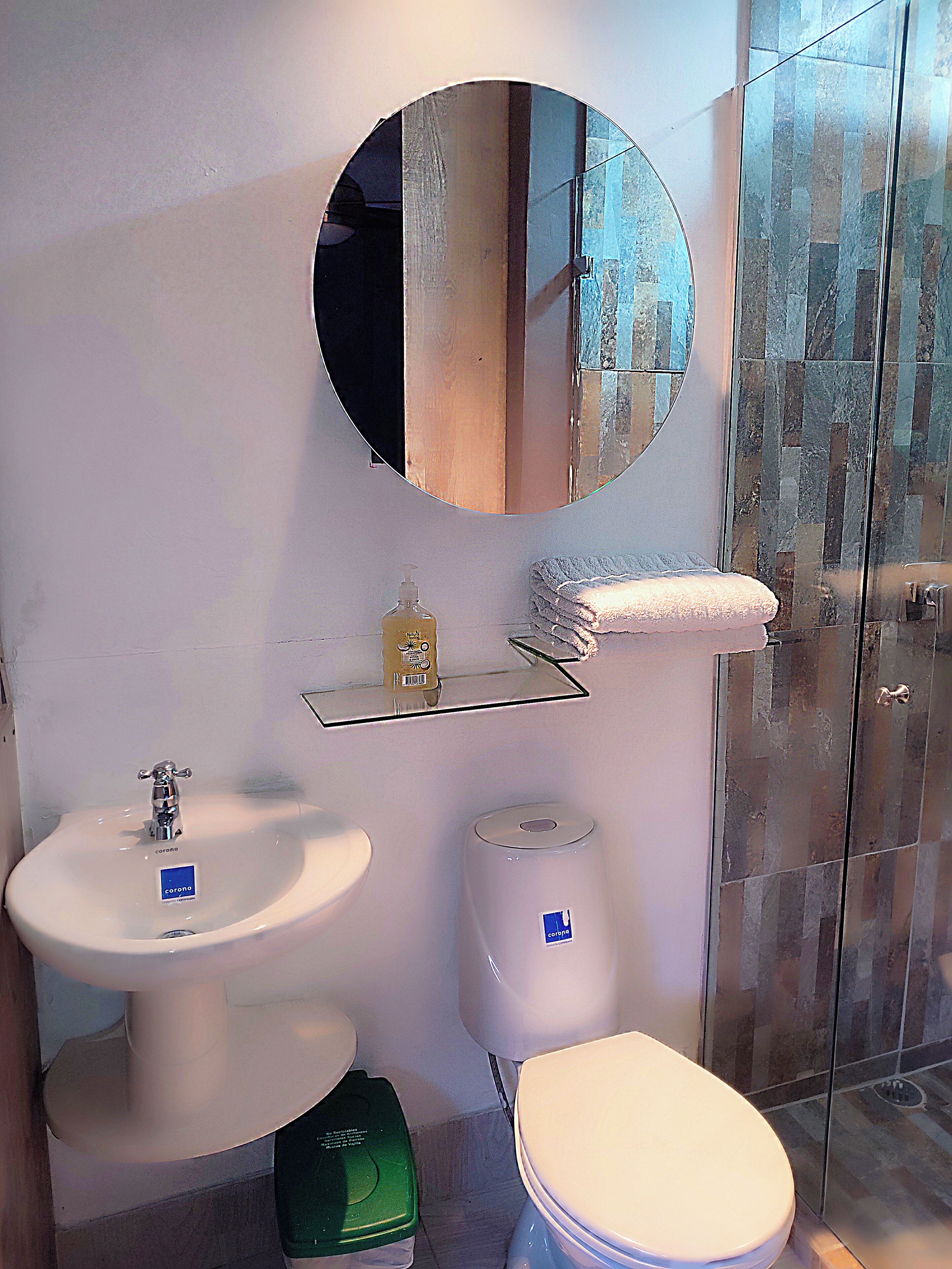 A bathroom with a sink, toilet, and a glass shower enclosure.