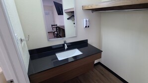 A bathroom with a black sink, a mirror, and a wooden vanity. - Red Roof Inn Byron (Byron)