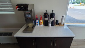 Un espace dédié au café, équipé d’une machine à café, de deux cafetières et de divers condiments.