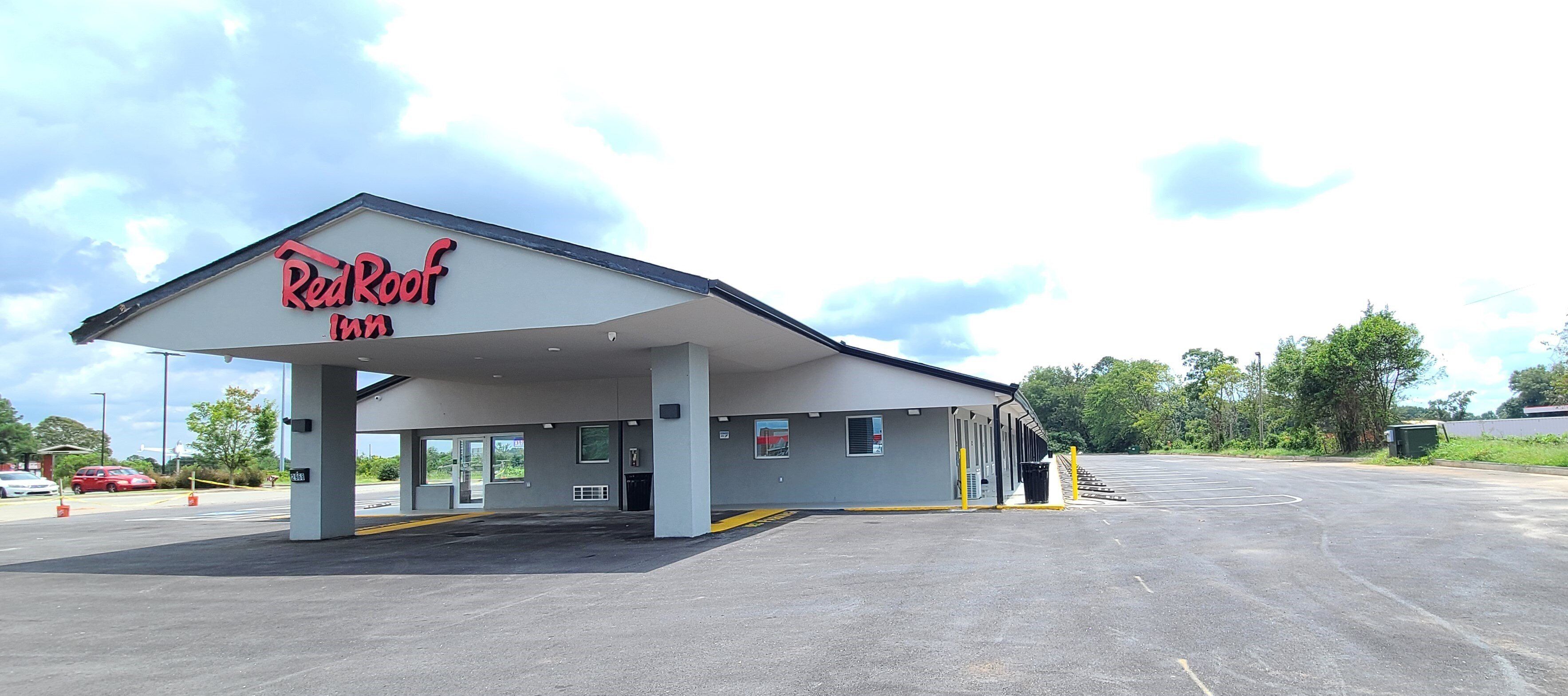 A Red Roof Inn with a covered parking area and a clear sky.