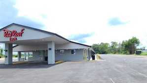 Un hôtel Red Roof Inn doté d’un parking couvert et offrant une vue sur un ciel dégagé.