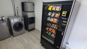Une buanderie équipée d’un lave-linge, d’un sèche-linge et d’un distributeur automatique de collations.