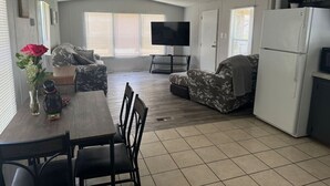 A compact living space with a dining area, sofa, and a refrigerator. - Casita on the Ranch-wildlife,sunsets, stars, relax (Spring Branch)