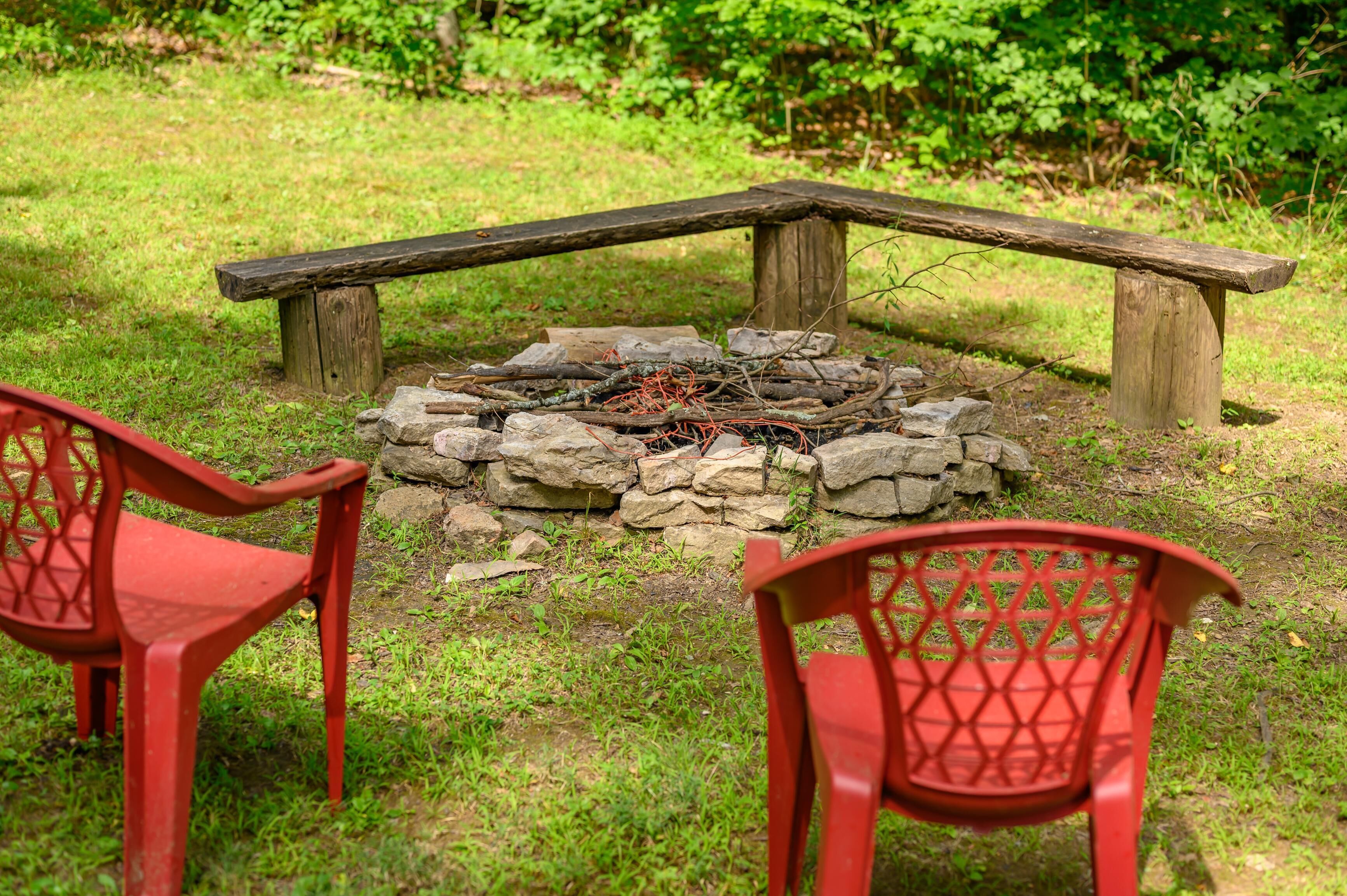Un espacio de estar al aire libre rústico, con una chimenea de piedra y bancos de madera.