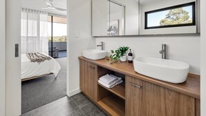 Un bagno moderno con due lavabi a vasca, uno specchio grande e vista sull'esterno.