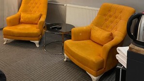 A room with two matching armchairs, a small table, a mirror, and a radiator. - VALERON SUITE PREMIUM (Istanbul)