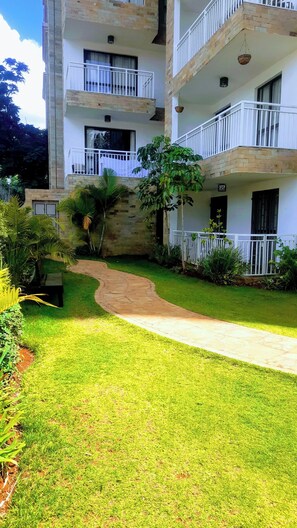 Stroll through the beautifully maintained garden, featuring a paved pathway and lush greenery.