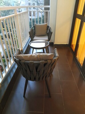 Relax on the balcony with a seating area featuring two comfortable chairs and a small table.