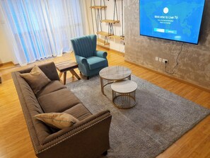 Relax in this stylish living room with a leather sofa, armchair, and flat-screen TV.