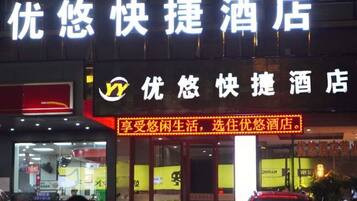 A hotel sign with illuminated text and a logo.