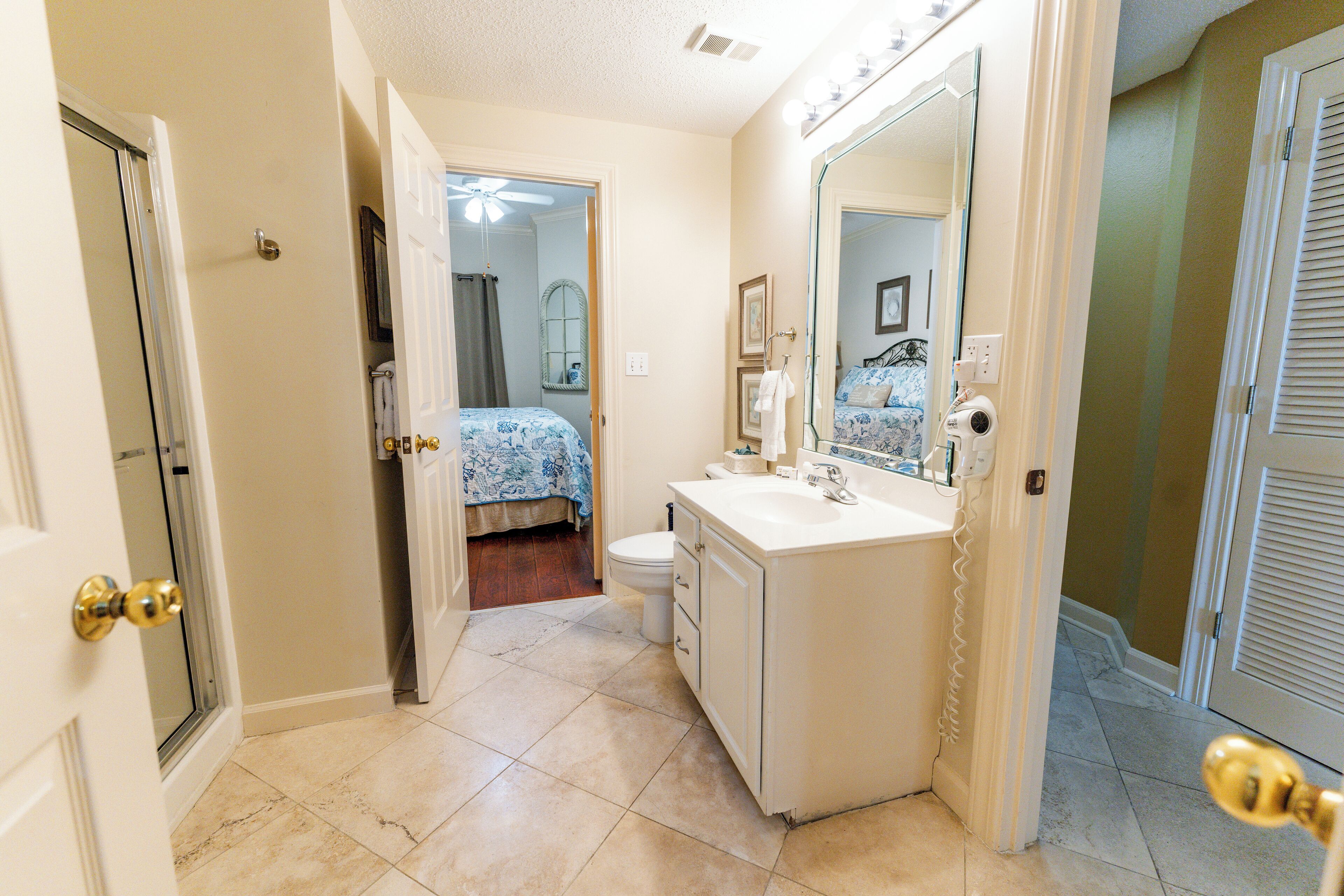 A bathroom with a white sink, mirror, and toilet.