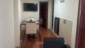 A narrow hallway with a dining area featuring a table, chairs, and a TV mounted on the wall. - Cozy, secure and private suite  (Guayaquil)