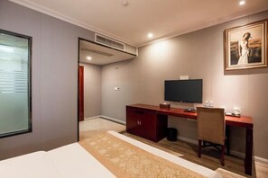 A hotel room with a bed, a desk with a computer, a chair, a TV, and a painting on the wall. - Boerman Hotel (Chengdu Conference and Exhibition Center) (Chengdu)