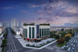 A multi-story building with a central atrium, surrounded by a parking lot and a cityscape in the background. - Boerman Hotel (Chengdu Conference and Exhibition Center) (Chengdu)