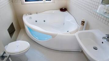 A modern bathroom with a freestanding bathtub, a sink, and a toilet.