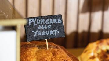 A loaf of plumcake with a sign indicating it is served with yogurt.