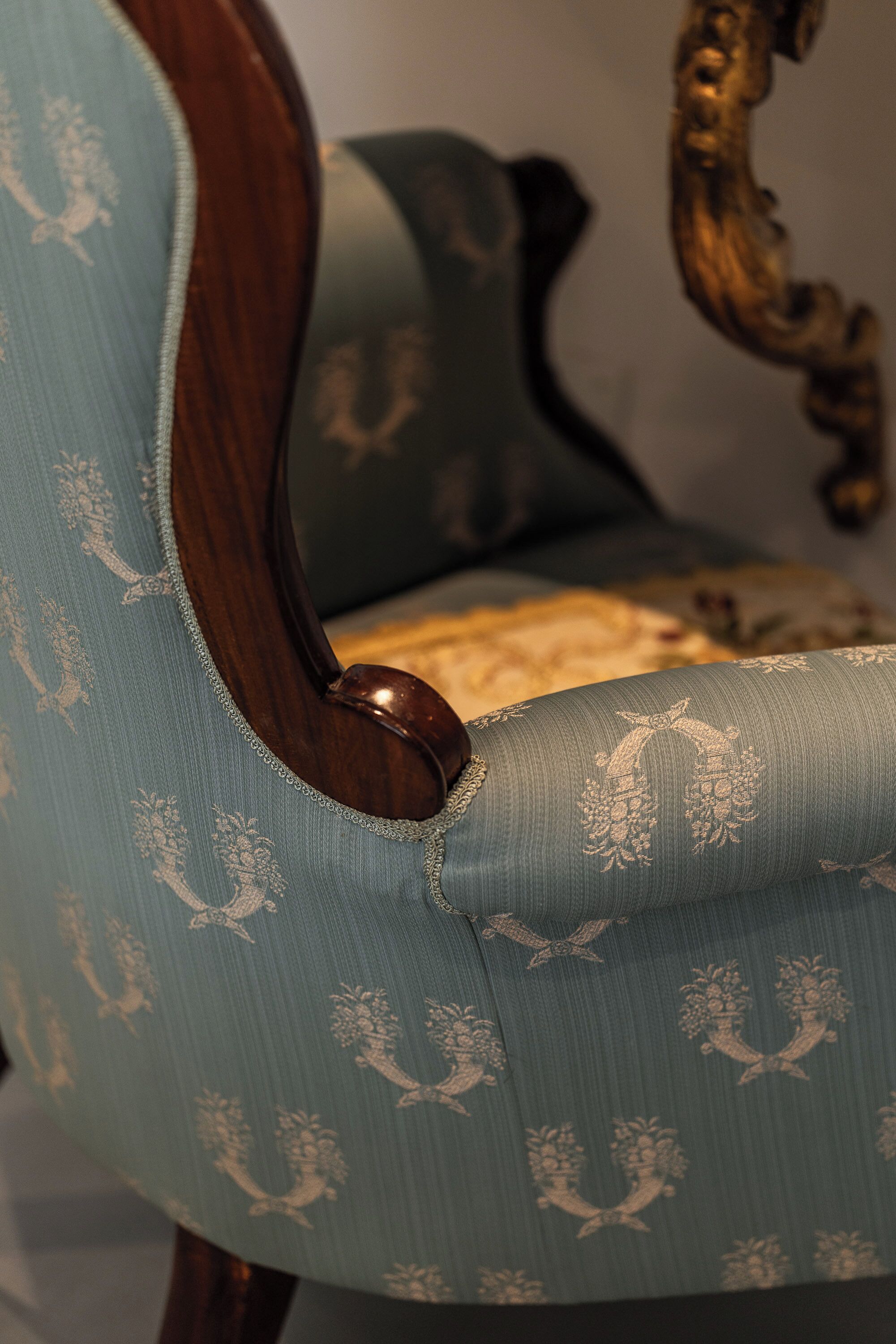 Primer plano de una silla con estructura de madera y tela estampada.