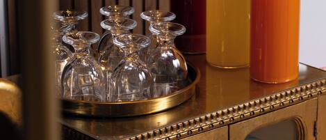 A wooden cabinet with glass doors, a tray with wine glasses, and three glasses of orange juice.