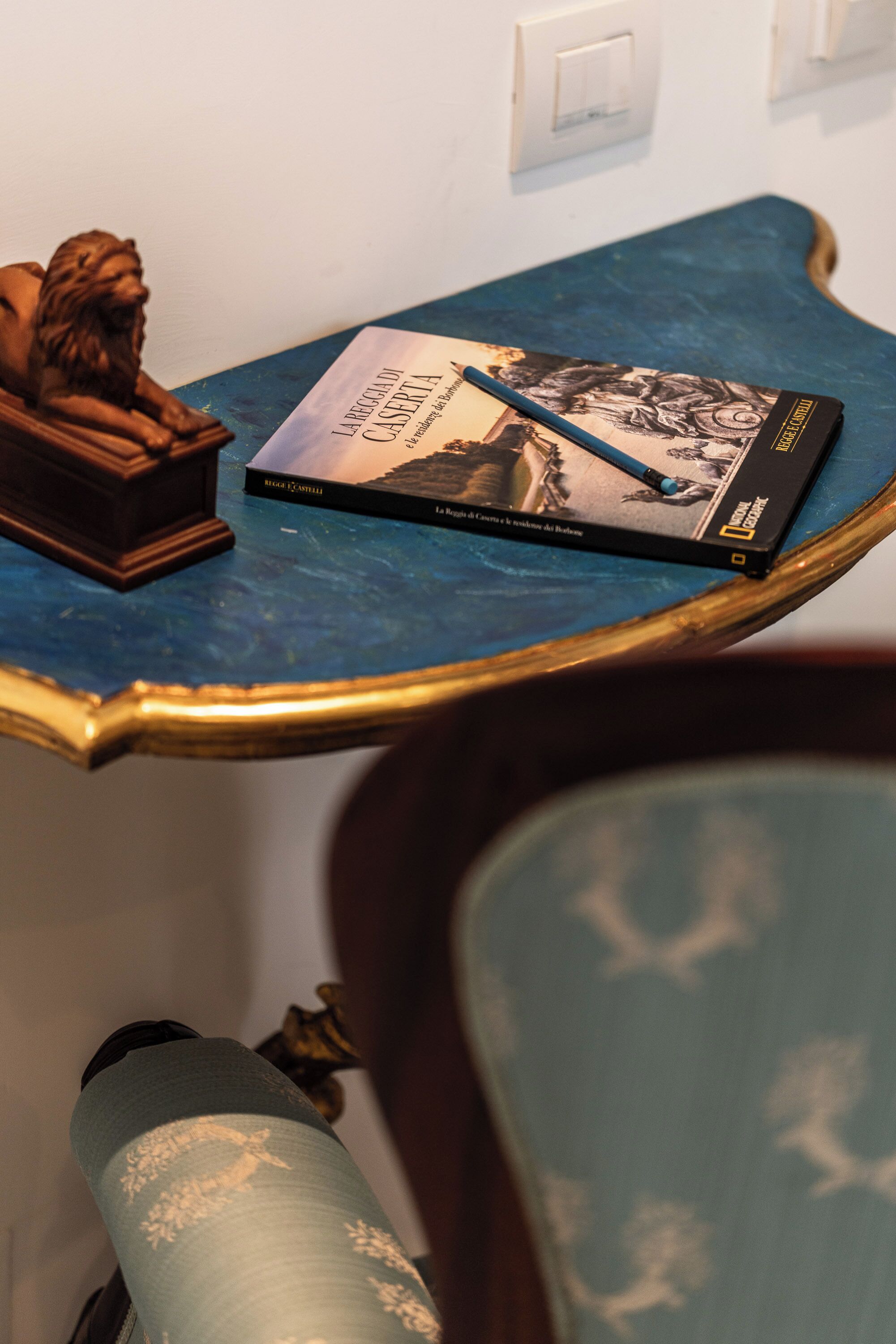 Ein Buch mit dem Titel 'L'ARQUEOLOGIA DI CASERTA' auf einem blauen Tisch mit goldener Rahmung.