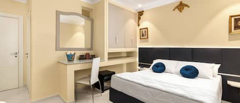 A bedroom with a bed, a desk, a chair, a wardrobe, and a mirror.