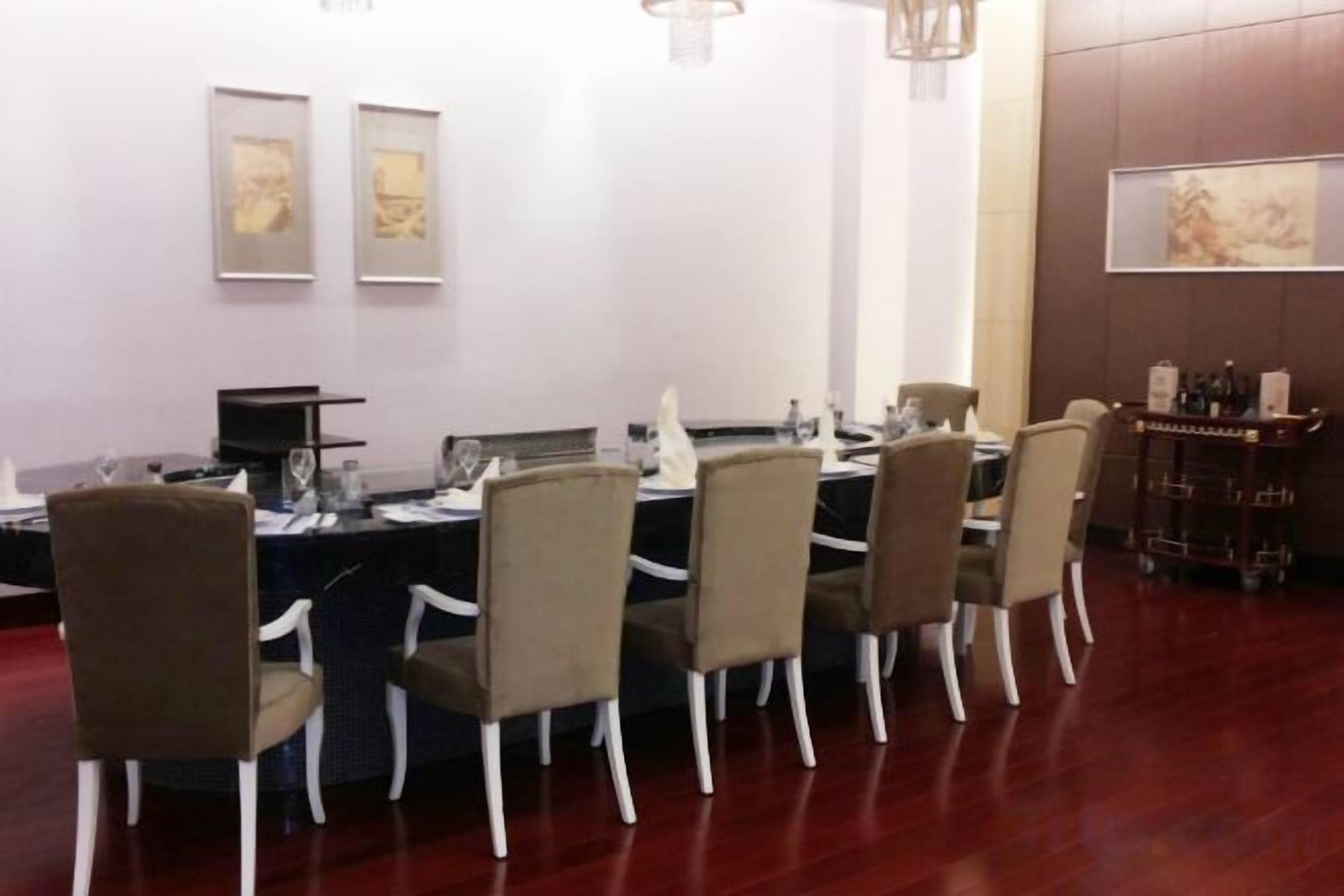 A conference room with a long table, chairs, a projector, and a whiteboard.