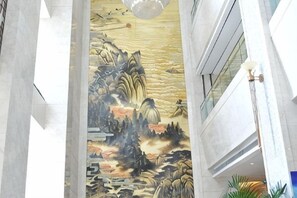 A corridor with a mural depicting a landscape scene. - Jimo Huaxi Hotel (Qingdao)