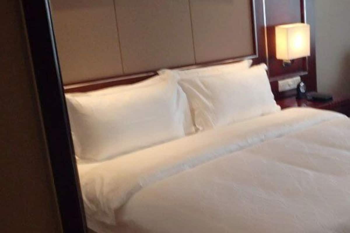 Ein Hotelzimmer mit einem Bett, einem Nachttisch und einer Lampe.
