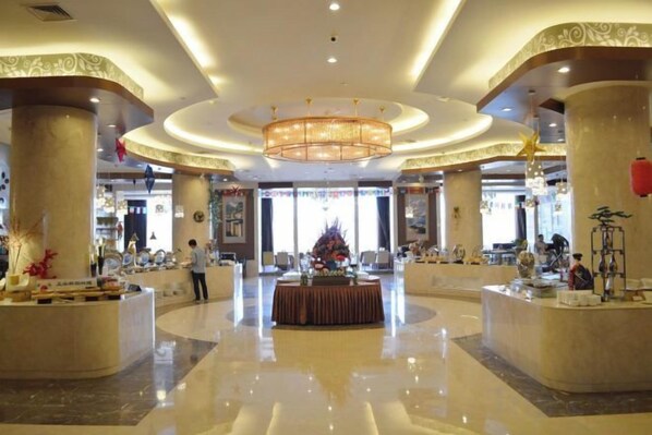 A spacious lobby with a central reception desk, large columns, and a chandelier. - Jimo Huaxi Hotel (Qingdao)