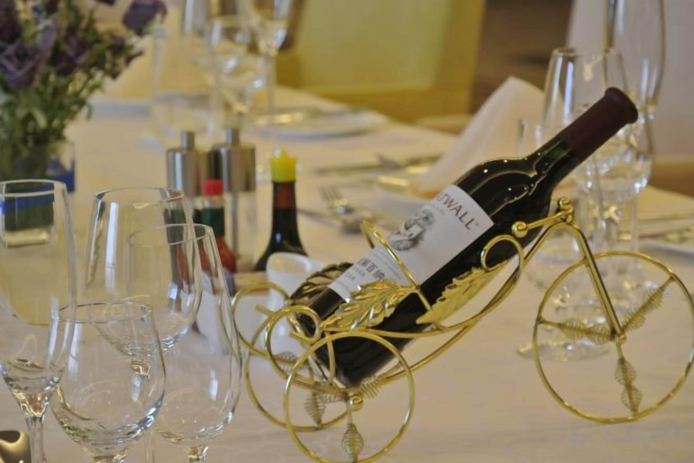 Mesa dispuesta con copas de vino, una botella y un elegante botellero.