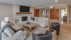 A modern living room with a fireplace, a sofa set, a coffee table, and a fireplace screen. - Gorgeous Waterfront Retreat (Pequot Lakes)