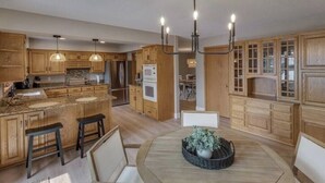 A spacious kitchen with wooden cabinets, a central island, and pendant lighting. - Gorgeous Waterfront Retreat (Pequot Lakes)