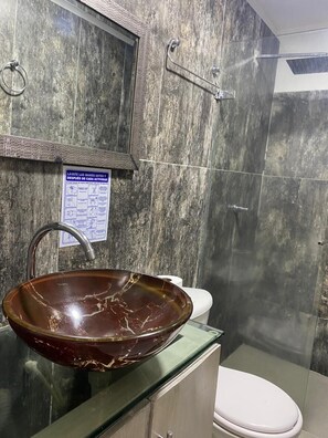 Chuveiro, toalhas de banho, papel higiênico