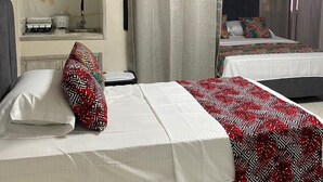 A hotel room with two beds, a kitchenette, and a bathroom. - Beach Apartments Nabusimake (Santa Marta)