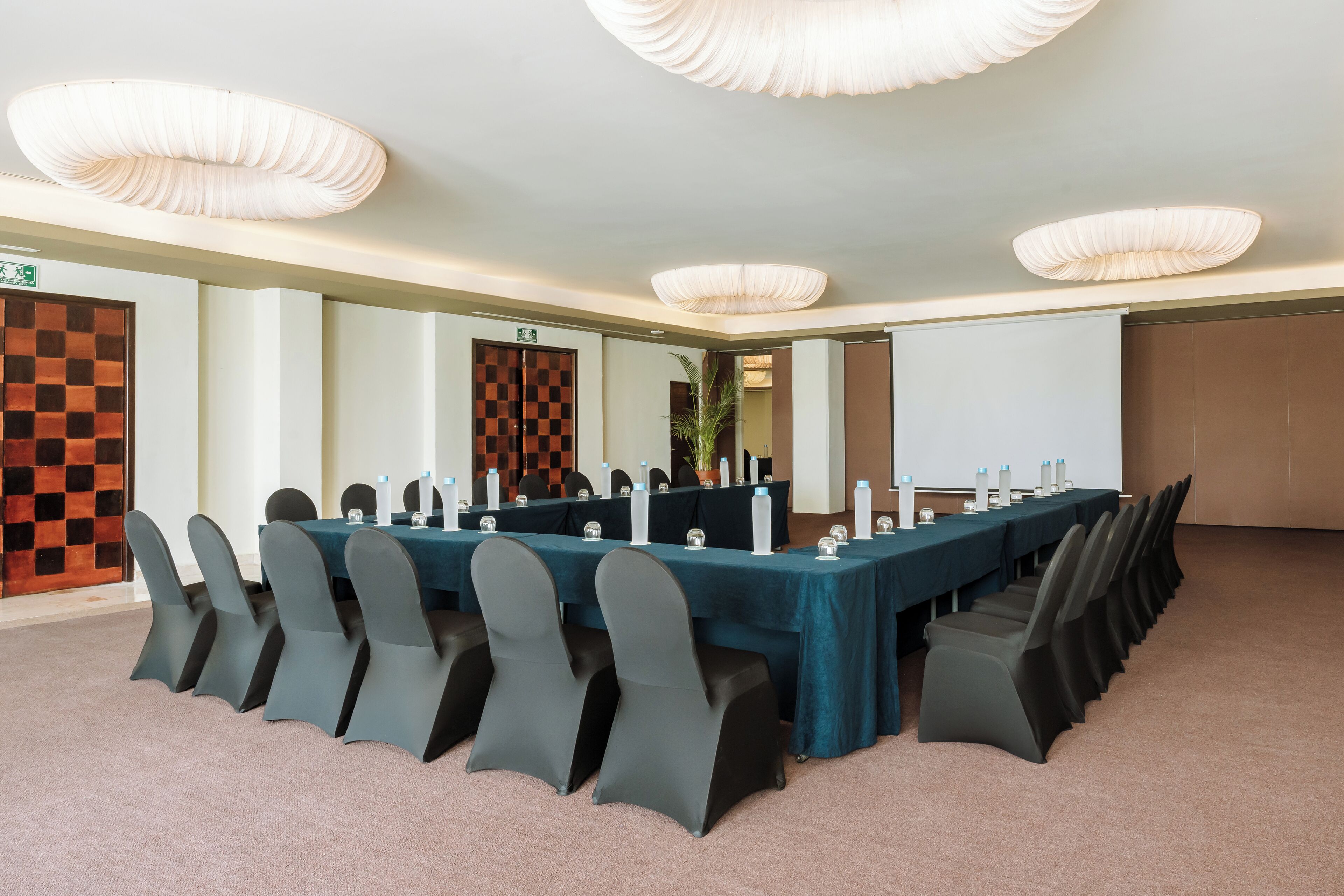 A conference room with a long table, chairs, and a whiteboard.