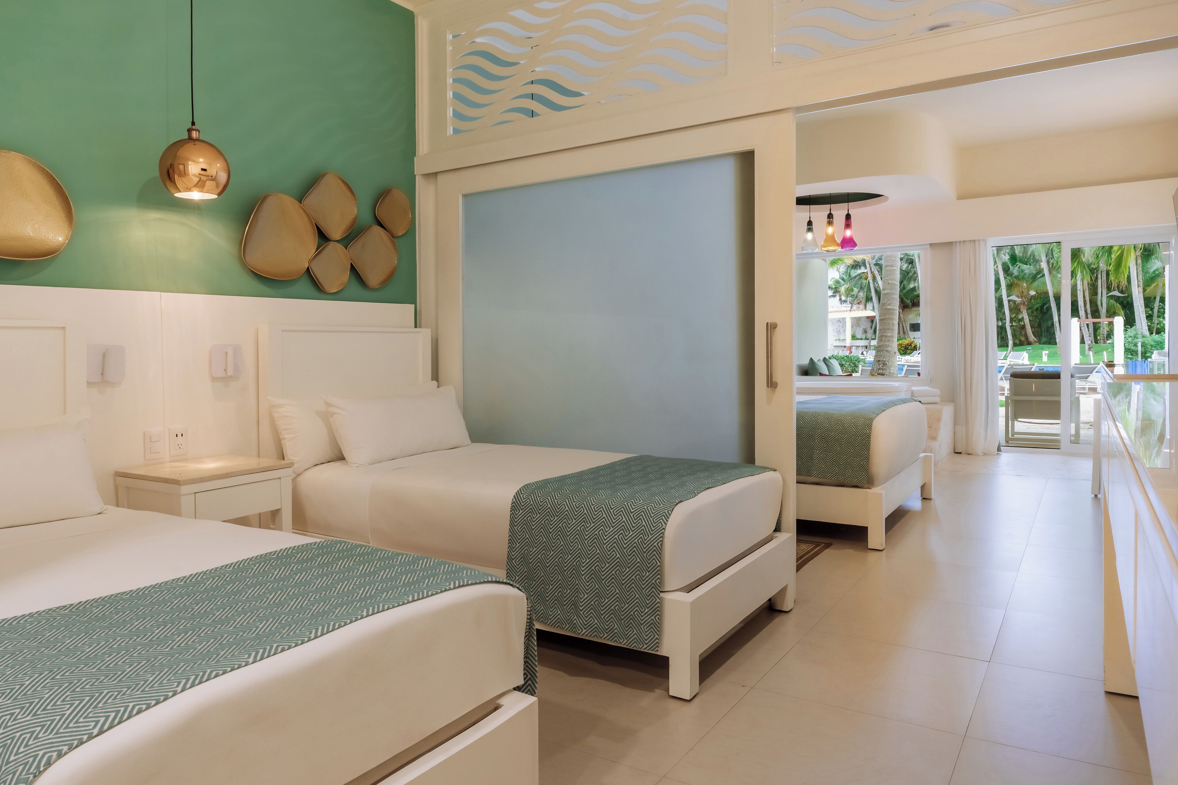 A hotel room with two beds, a large window, and a view of palm trees.