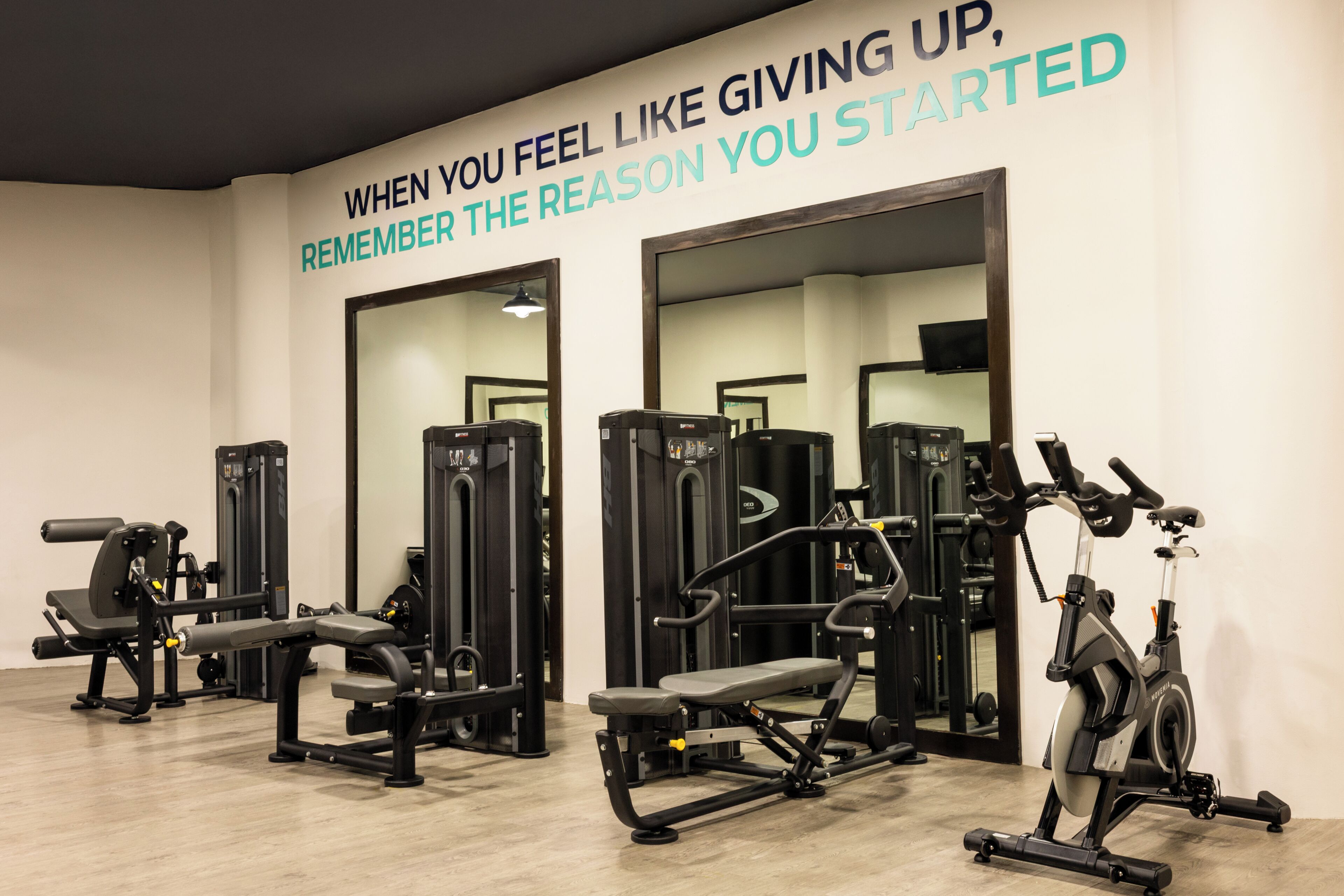 Una palestra con attrezzature per esercizi e una frase motivazionale sulla parete.