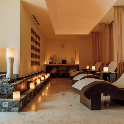 A spa area with massage chairs, candles, and a stone wall.