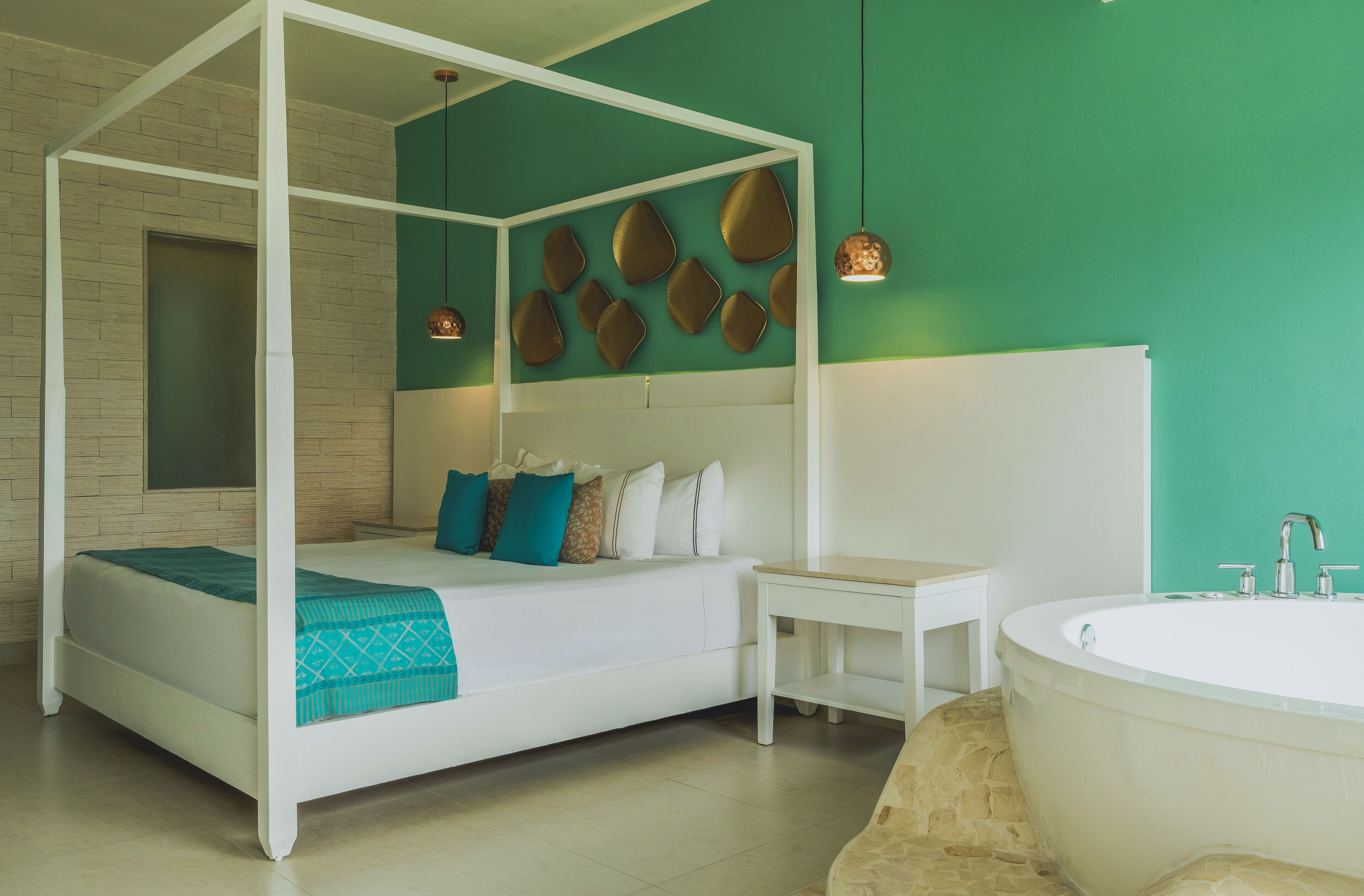 A four-poster bed with a white frame, a small bedside table, and a large bathtub.
