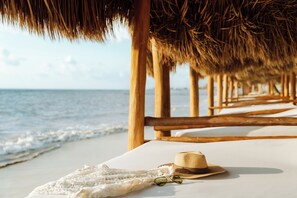 Nyilvános parton, fehér homok, napernyők és strandlepedők