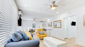 A modern living room with a sofa, a yellow armchair, and a white coffee table. - Spacious 1 Bedroom Apartment, Steps from the beach (Hollywood)