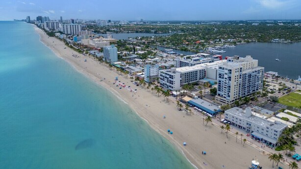 An aerial view of a coastal city with a beach, high-rise buildings, and a marina. - Spacious 1 Bedroom Apartment, Steps from the beach (Hollywood)