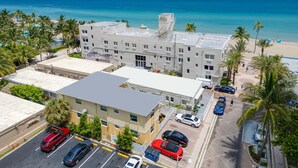 Un hôtel à plusieurs étages doté d’un parking, situé à proximité d’une plage et offrant une vue sur l’océan.