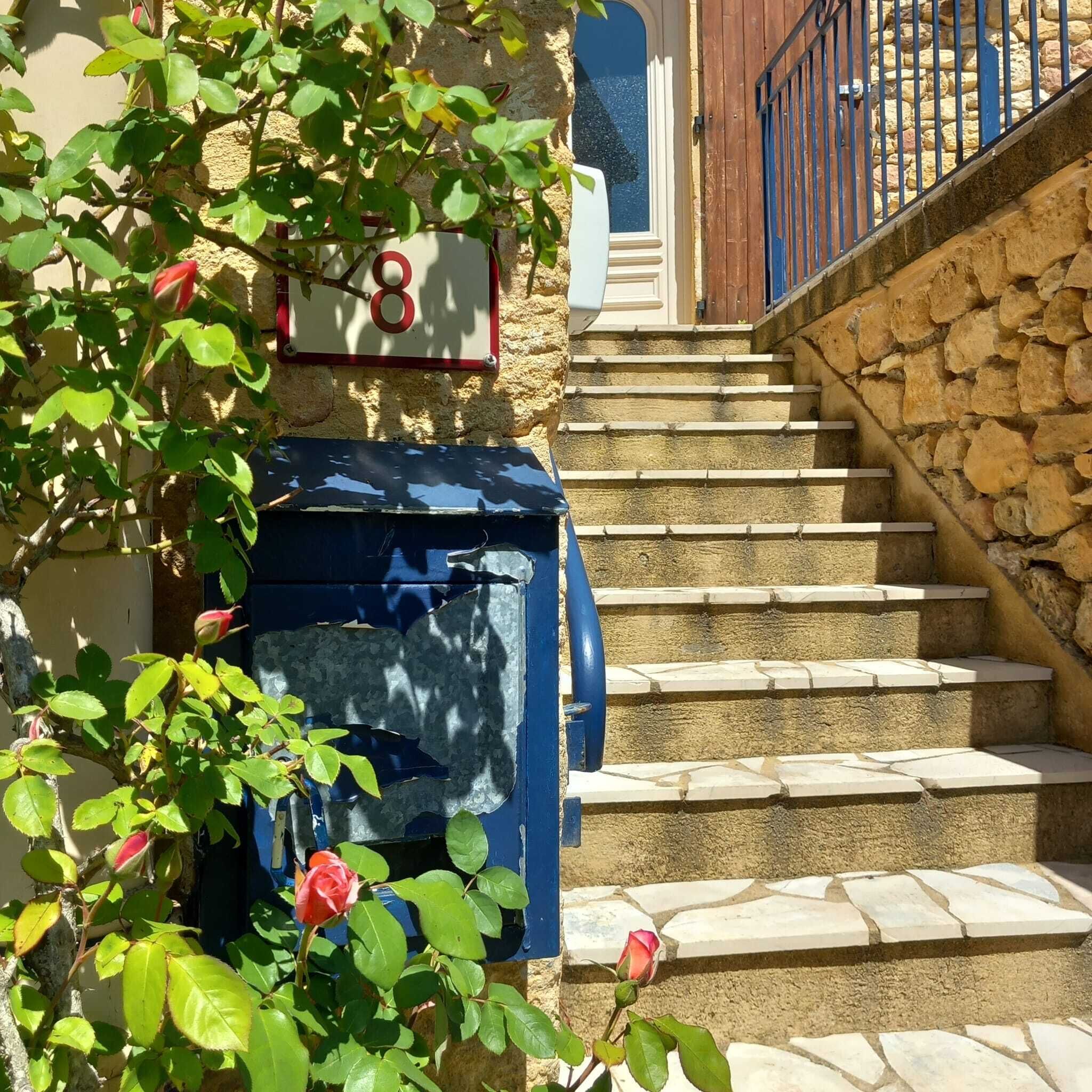 A stone staircase leading to a door with a mailbox marked '8'.