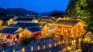 A traditional building with a water wheel, stone steps, and a stone wall. - Waiting For You at Yunshuiyao Inn (Nanjing County)