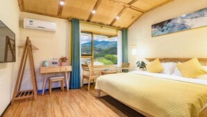 A bedroom with a bed, desk, chair, and a view of a landscape through a window. - Waiting For You at Yunshuiyao Inn (Nanjing County)