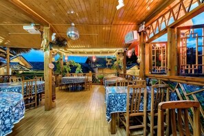 A wooden interior with tables and chairs, large windows, and a view of the sea. - Waiting For You at Yunshuiyao Inn (Nanjing County)